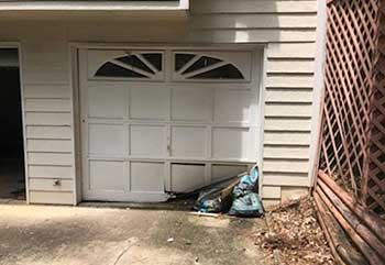 Inside view of broken garage door with bent panels needing replacement in La Canada Flintridge, CA