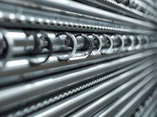 Detailed close-up image of multiple metal garage door springs aligned on a rack, showcasing professional-grade spring repair and replacement service.