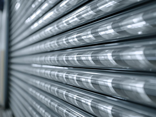 Detailed close-up of coiled steel torsion springs mounted on a garage door shaft, illustrating essential garage door mechanics.