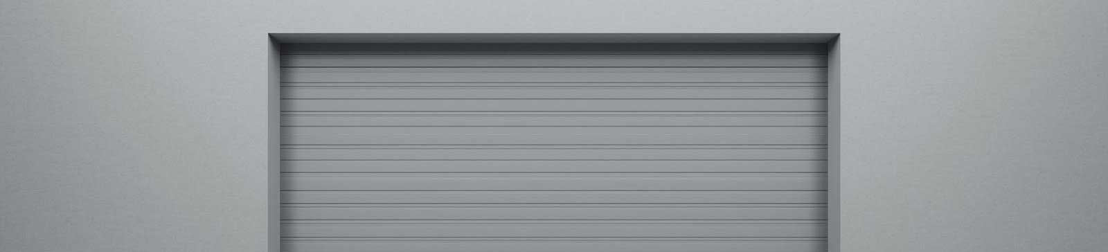 Closed modern overhead garage door with horizontal panels set in a plain light grey wall, representing a secure and efficient garage solution.